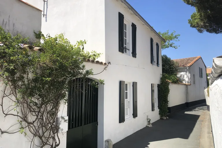 Ruelle et maison blanche aux volets gris à La Couarde-sur-Mer